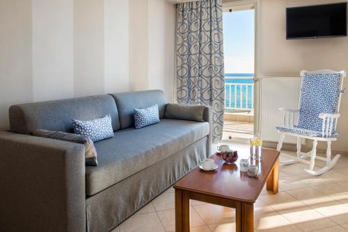 新卡利克拉蒂業的住宿－Georgalas Sun Beach Resort，客厅配有沙发和桌子