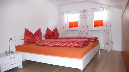 a bedroom with a bed with red pillows on it at Apartment Spitzenblick in Garmisch-Partenkirchen