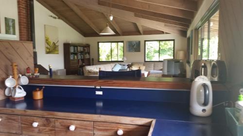 a kitchen with a blue counter top and a living room at Waiotemarama Falls Lodge in Opononi