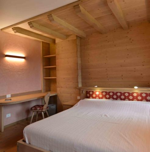 a bedroom with a bed in a wooden room at Antico fienile in Belluno