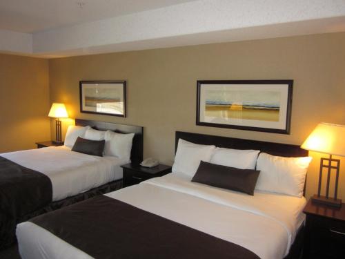 a hotel room with two beds and two lamps at Franklin Suite Hotel in Fort McMurray