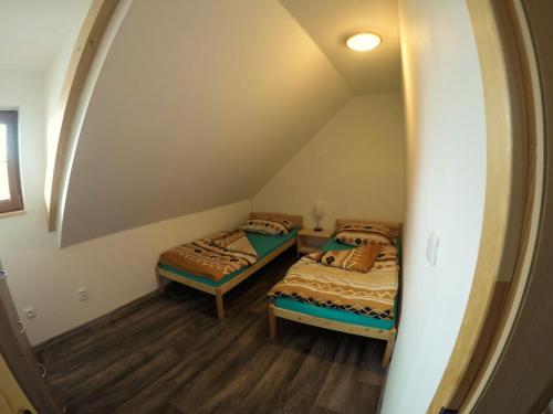 2 Betten in einem Zimmer mit einem Bogenfenster in der Unterkunft Roubenka U Třeboně in Domanín