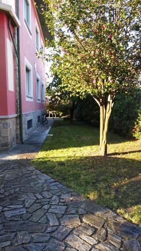 a tree sitting next to a building with a brick sidewalk at Casa Orisca in Lesa