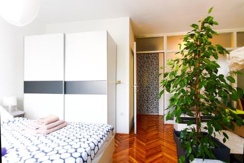 ein Schlafzimmer mit einem Bett und einer Topfpflanze in der Unterkunft Apartment Melon in Zagreb