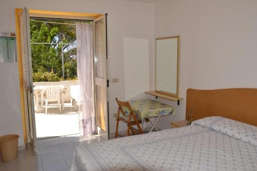 Schlafzimmer mit einem Bett und einer Tür zu einer Terrasse in der Unterkunft Appartamenti Villa Annunziata in Ischia