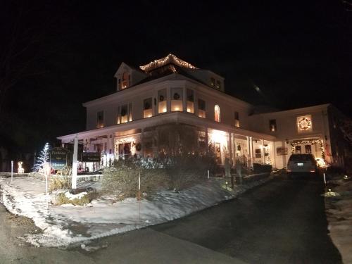 a large building with a clock on top of it at night at The Perkins House in Cornish