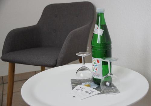 uma garrafa verde numa mesa branca com uma cadeira em Hotel Jägerhof em Ratingen