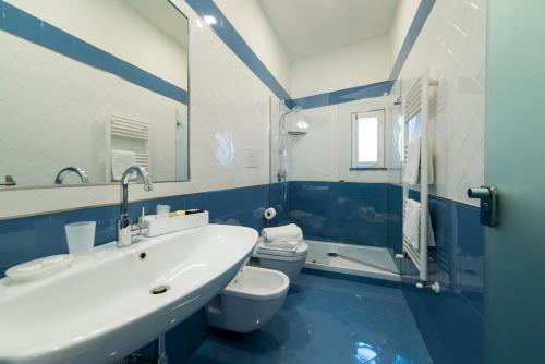 een blauwe en witte badkamer met een wastafel en een toilet bij B&B Umberto in Vietri
