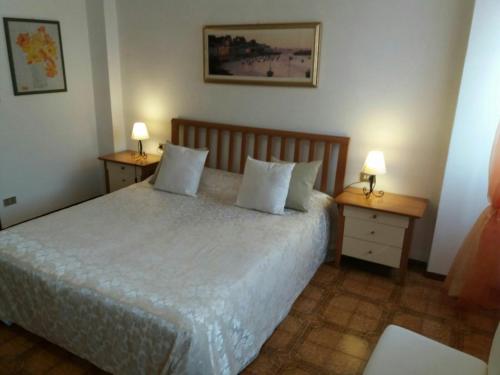 バルドリーノにあるMatteotti Houseのベッドルーム1室(ベッド1台、ナイトスタンド2台、ランプ2つ付)