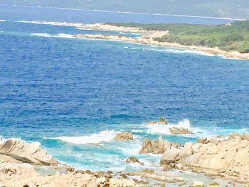 a view of the ocean with rocks in the water at Les Villas MarInCelu in Porto Pollo