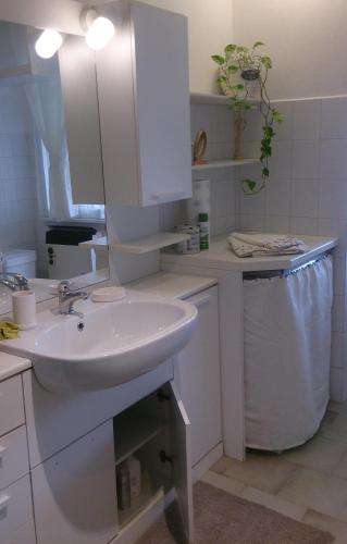 a white bathroom with a sink and a mirror at B&B Family Home in Soresina
