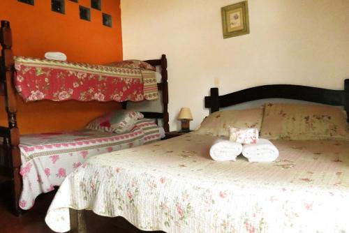 a bedroom with a bed with two towels on it at Pousada Toca das Bromelias in Campos do Jordão