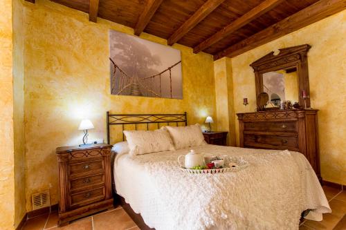 a bedroom with a large bed and a mirror at Casa Valle del Genal in Igualeja