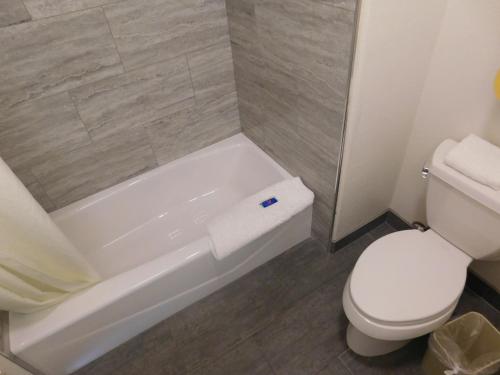 a bathroom with a toilet and a tub and a toilet paper roll at Fisherman's Cove Inn in Monterey