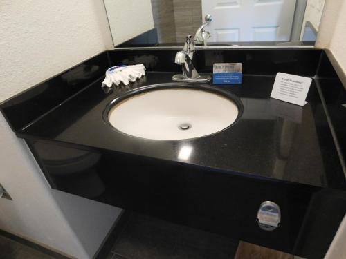 a bathroom sink with a black counter top at Fisherman's Cove Inn in Monterey