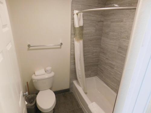 a bathroom with a toilet and a shower and a tub at Fisherman's Cove Inn in Monterey