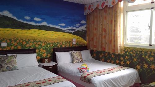 a bedroom with two beds and a painting on the wall at Mei Di Ya House in Yuli
