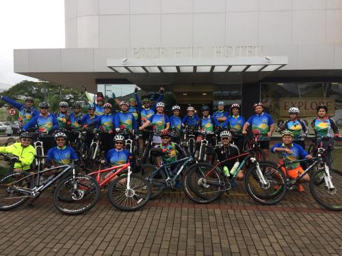 a group of people posing for a picture with their bikes at Blue Hill Hotel in Timbó