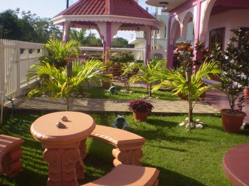 a garden with a bench and a gazebo at Beya Suites in Punta Gorda