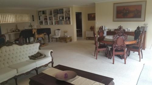 a living room with a couch and chairs and a table at Hilltop Hideaway in Ninderry
