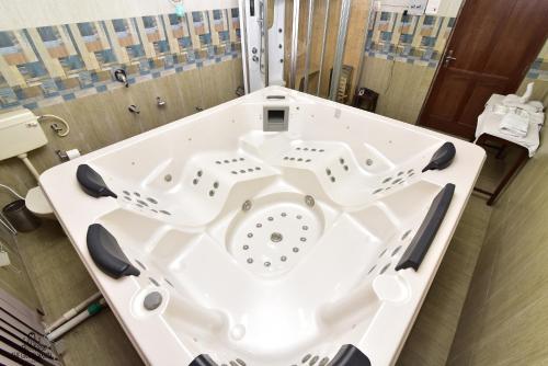 a bath tub with two sinks in a bathroom at The Grand Mamta in Srinagar