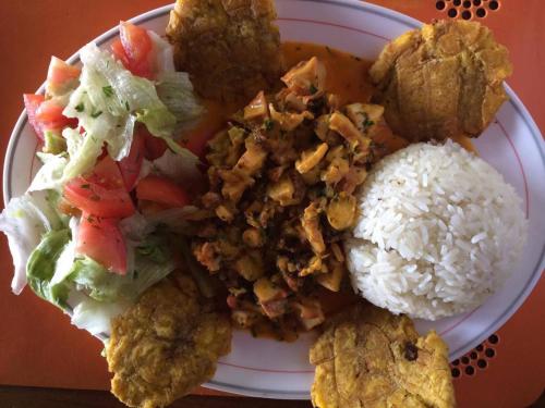 a plate of food with rice and meat and vegetables at Hosteria Cumilinche in Same