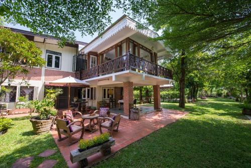 a patio area with chairs, tables, and a patio table at Phuttal Residence in Phra Nakhon Si Ayutthaya