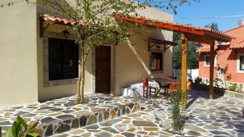 
a patio area with chairs, tables and umbrellas at Villa Argo, Feakia in Agios Gordios
