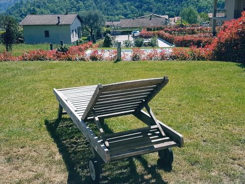 a wooden bench sitting in the grass in a field at Appartamenti Zerboni in Lenno