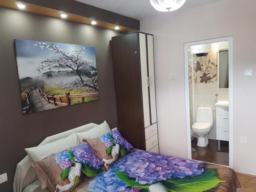 a bedroom with a bed with purple flowers on it at Apartments Vila Galileo in Budva