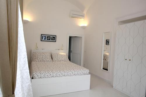 Un dormitorio blanco con una gran cama blanca. en B&B Nel Mar, en Vico Equense