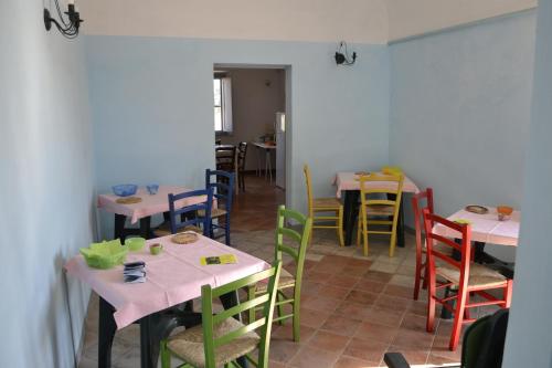 jadalnia ze stołami i krzesłami z kolorowymi krzesłami w obiekcie Podere S.Giulia - casale Banditelle w mieście Venturina Terme