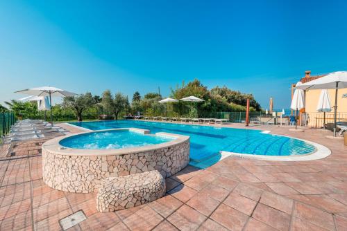a large swimming pool with a stone wall around it at Agriturismo Costadoro in Bardolino