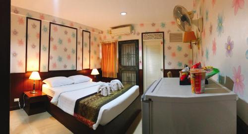 a bedroom with a bed and a table in it at Orchid Resort in Lat Krabang