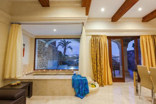 a large bathroom with a tub and a large window at Carini Farmhouses in Għarb