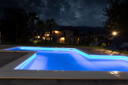 una piscina con iluminación azul por la noche en Albergo Diffuso Polcenigo B.Vittorio, en Polcenigo