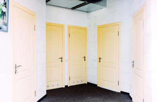 a row of four white doors in a room at Happy Hostel Kiev in Kyiv