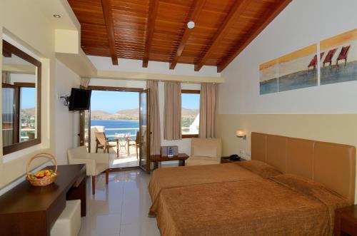a bedroom with a bed and a view of the ocean at Lemnos Village Resort Hotel in Platy