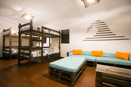 a room with two bunk beds and a bench at Douro Surf Hostel in Vila Nova de Gaia
