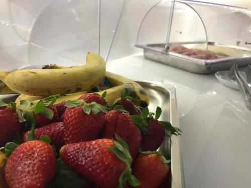 a plate of strawberries and a banana on a table at Palazzo Iaquinto in Santa Maria di Castellabate