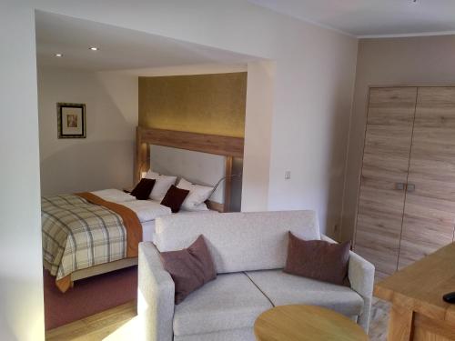 a bedroom with a bed and a couch in a room at Landhaus Silberberg in Winterberg