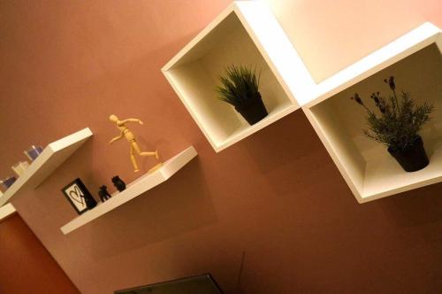 una habitación con estanterías blancas en la pared con plantas en Apartment in Ladang Tok Pelam, en Kuala Terengganu