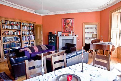 a living room with a couch and a piano at Epicurean Clerk Apartment in Edinburgh