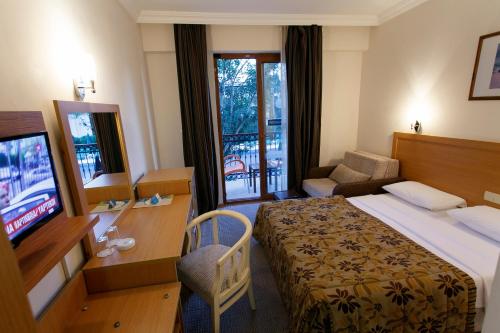a hotel room with a bed and a television at Perdikia Beach in Oludeniz