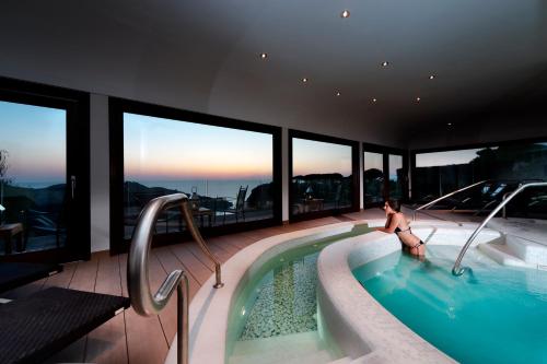 a woman sitting in a swimming pool on a house at San Montano Resort & Spa in Ischia