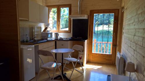 une cuisine avec une table et des chaises dans une cabine dans l'établissement Gîtes Le Panorama, à Collonges-sous-Salève