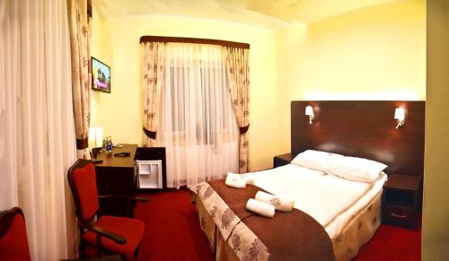 a hotel room with a bed with towels on it at Zefir SPA in Polańczyk