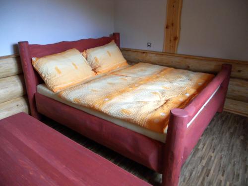 a bed in a room with a red frame at Penzion U Fábů in Lednice