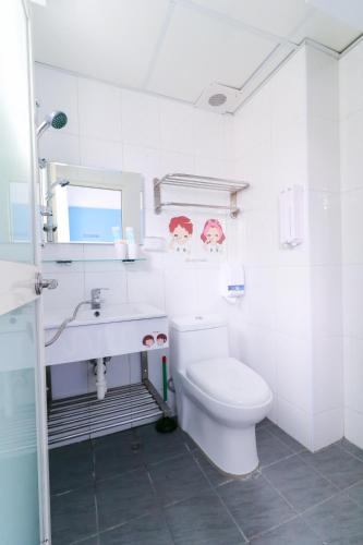 a white bathroom with a toilet and a sink at Long house in Taichung