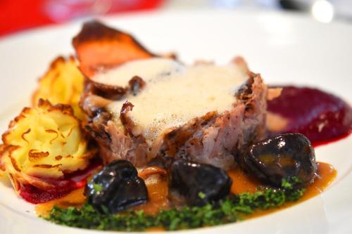 a plate of food with a piece of meat and vegetables at Zefir SPA in Polańczyk